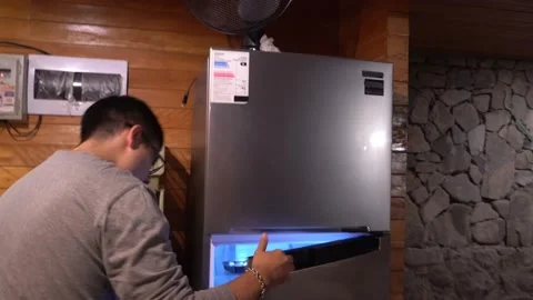 A man taking things out of the fridge at night in 4k Video stock 199502003