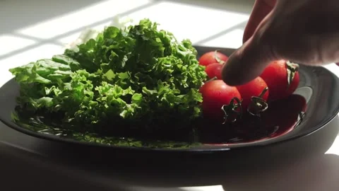 Man taking the tomato from the plate with with vegetables Stock Footage 133344520
