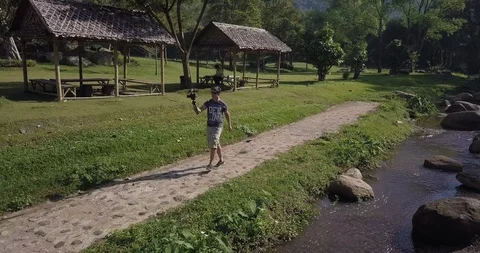 A man is taking video and walk beside a river Chiang Mai Thailand Stock Footage 100749399