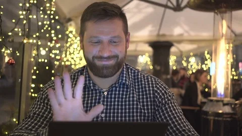 Man taking video call by tablet app, cafe, night, close steadicam shot  库存影片 72782531