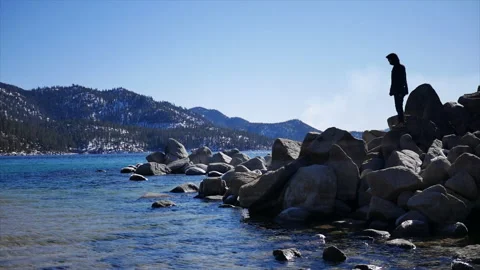 Man taking in the view on a beach in Lake Tahoe Stock Footage