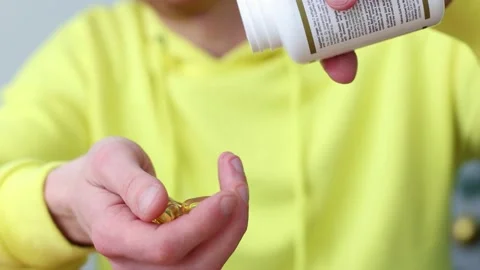 Man taking vitamins out of pill bottle. Closeup. Healthcare and medicine. Video stock 170178308