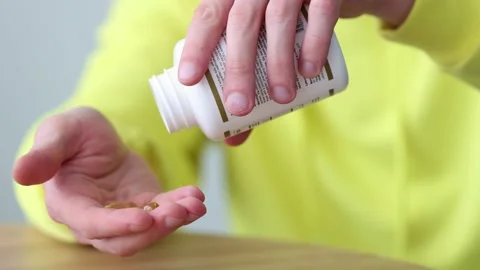 Man taking vitamins out of pill bottle. Closeup. Healthcare and medicine. Video stock 170476858