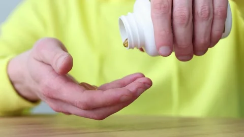 Man taking vitamins out of pill bottle. Closeup. Healthcare and medicine. Video stock 172218392