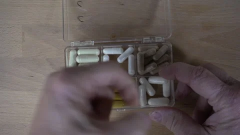 A man taking vitamins from a pill box Stock Footage 222973053