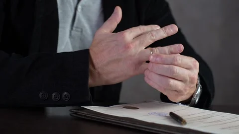 Man taking off wedding ring, close-up. Man with wedding ring on finger sitt.. Stock Footage 287547390