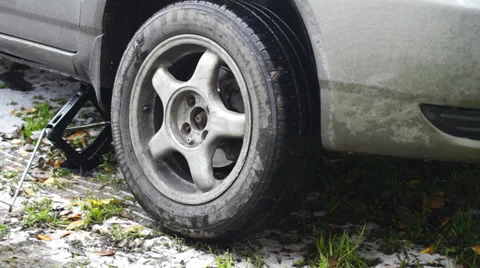 Man taking wheel off the car on lifting jack Stock Footage 33212231