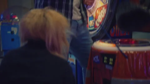 Man taking woman's hat and hitting it with a toy mallet on an arcade game Stock Footage 275002490