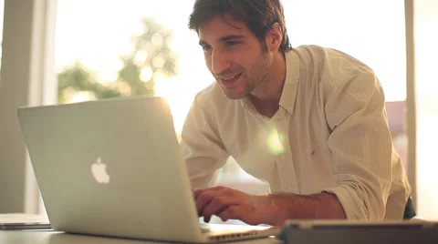 Man talk on cell phone while typing on laptop computer Stock Footage 63287179
