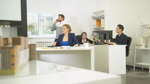 Man talk on the phone, workmates help him showing schemes of apartements Stock Footage 121796265