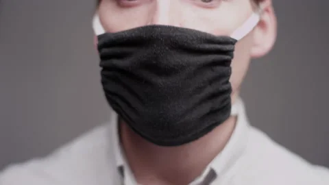 Man talking and smiling through his face mask to protect himself from COVID-19 Video stock 134267063