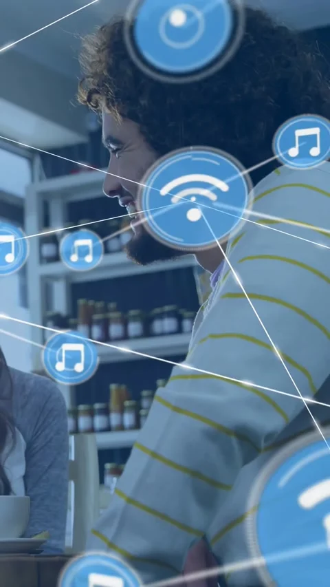 Man talking in cafe, sparking animated blue tech icons appearing over head-chest Stock Footage 334381743