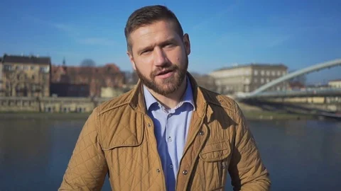 Man talking to the camera, show places on the background of the river, sunny day 库存影片 72709406