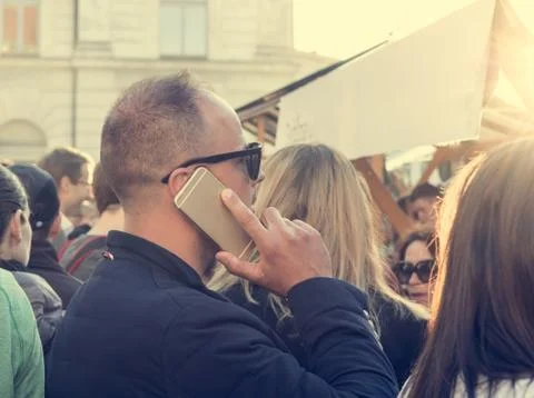 Man talking on a cell phone in the crowd. Stock Photos