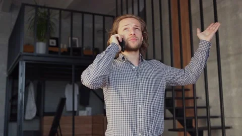 Man talking on cell phone in loft apartment Stock Footage 140937601