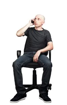 Man talking on a cell phone while sitting in an office chair Stock Photos