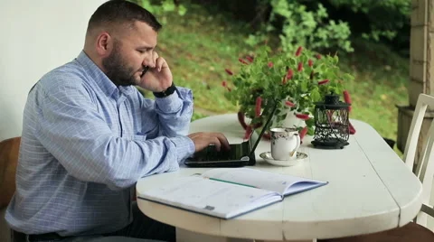 Man talking on cellphone and working on laptop Stock Footage 56240067