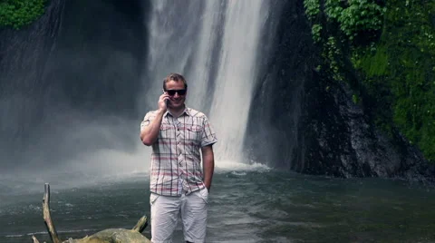 Man talking on cellphone next to the waterfall, slow motion shot at 240fps Stock-Footage 41663164