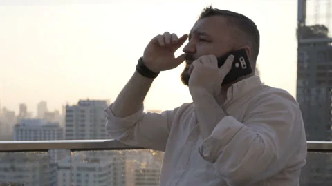 Man talking on cellphone on the rooftop during sunset Stock Footage 93232100
