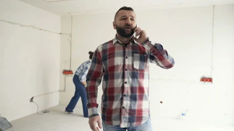 Man talking on cellphone while his girlfriend checking electric cables in their  스톡 동영상 95293847