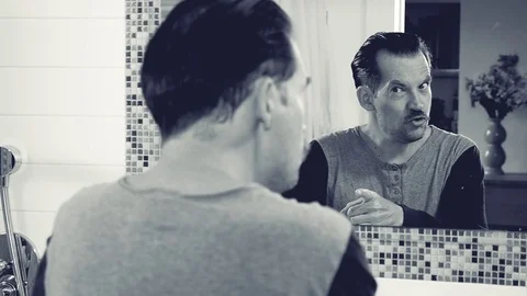 Man talking to himself angry in front of mirror slow motion black and white Stock Footage 82213754