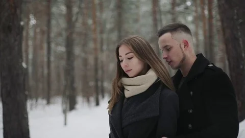 Man talking with his girlfriend in the winter forest and shows something around Stock Footage 73046370