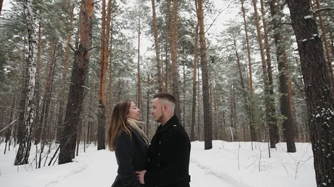 Man talking with his girlfriend in the winter forest and shows something around Stock Footage 73047383