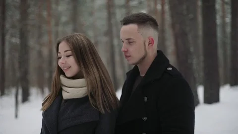 Man talking with his girlfriend in the winter forest and shows something around Stock Footage 73062848