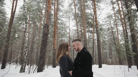 Man talking with his girlfriend in the winter forest and shows something around Stock Footage 73062948
