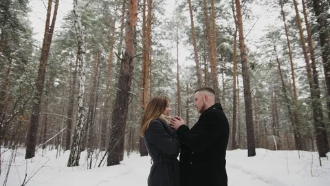 Man talking with his girlfriend in the winter forest and shows something around Stock Footage 73063051