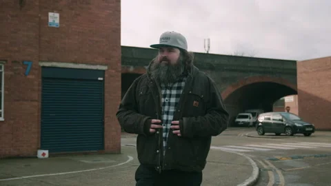 Man talking his jacket off while walking outside a brewery Video stock 131244708