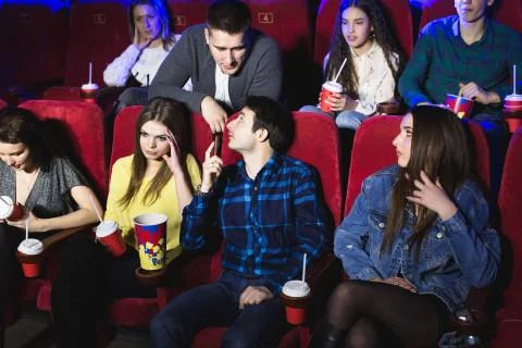 A man is talking loudly on the phone in a movie theater and prevents you from Stock Photos
