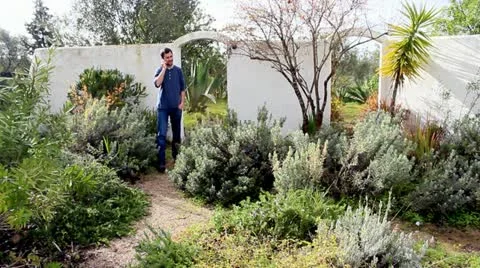 Man talking on mobile in garden Stock Footage 22184845