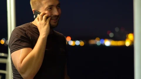 A man talking on a mobile phone against the backdrop of the night city. 動画素材 101401287