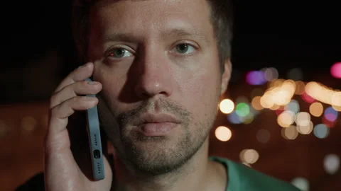 Man talking on a mobile phone, background of the lights of the metropolis Stock Footage 234961807