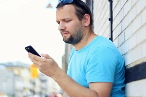 Man talking on mobile phone, brick wall background Stockbeeldmateriaal 7766084