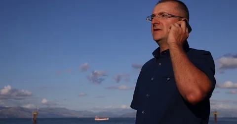 Man Talking a Mobile Phone Collaboration Communication Travel Freedom Blue Sky Stock Footage 70660916