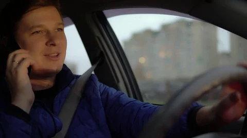 Man talking on mobile phone, in the evening driving in the city Stock Footage 81235341