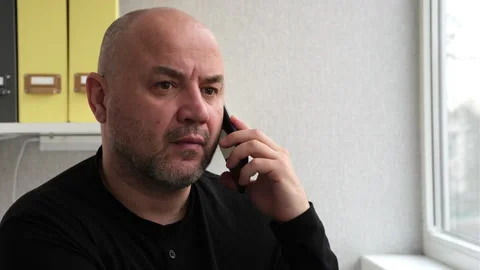 Man talking mobile phone indoors and get surprised. Businessman having call Stock Footage 243300878