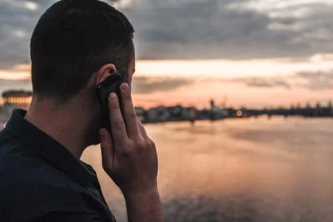 Man talking on mobile phone looking at evening city Stock Photos
