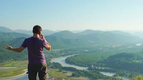 Man talking on a mobile phone on a mountain landscape background, Altai, Russia Vídeo Stock 143232171