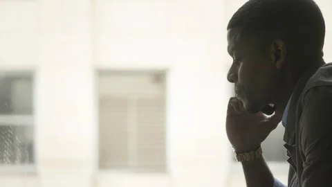 Man talking on the mobile phone next to a window Stock Footage 112055819