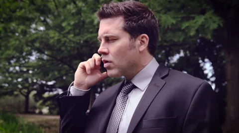 Man talking on mobile phone in park Stock Footage 64454893
