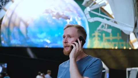 A man talking on a mobile phone at the space center 스톡 동영상 202402186