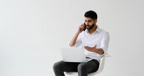 Man talking on mobile phone while using laptop Stock Footage 196079345