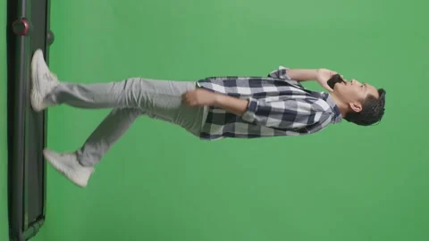 Man Talking On Mobile Phone While Walking On Green Screen In The Studio Stock Footage 248007357