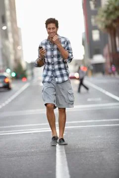 Man talking on a mobile phone while walking on the road Stock Photos