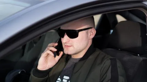 Man talking on a mobile phone while driving car. Stock Photos
