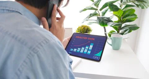 Man talking mobile phone while holding digital tablet with business analyze d Stock Photos