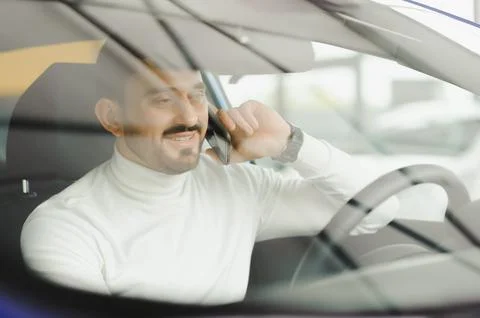 Man talking on a mobile phone while driving car. Stock Photos